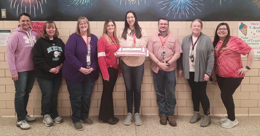 Elementary Paraprofessionals holding a cake