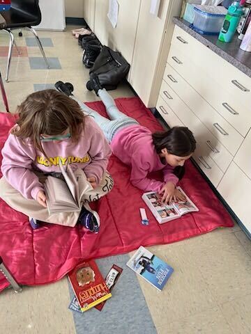 Students reading on sleeping bag