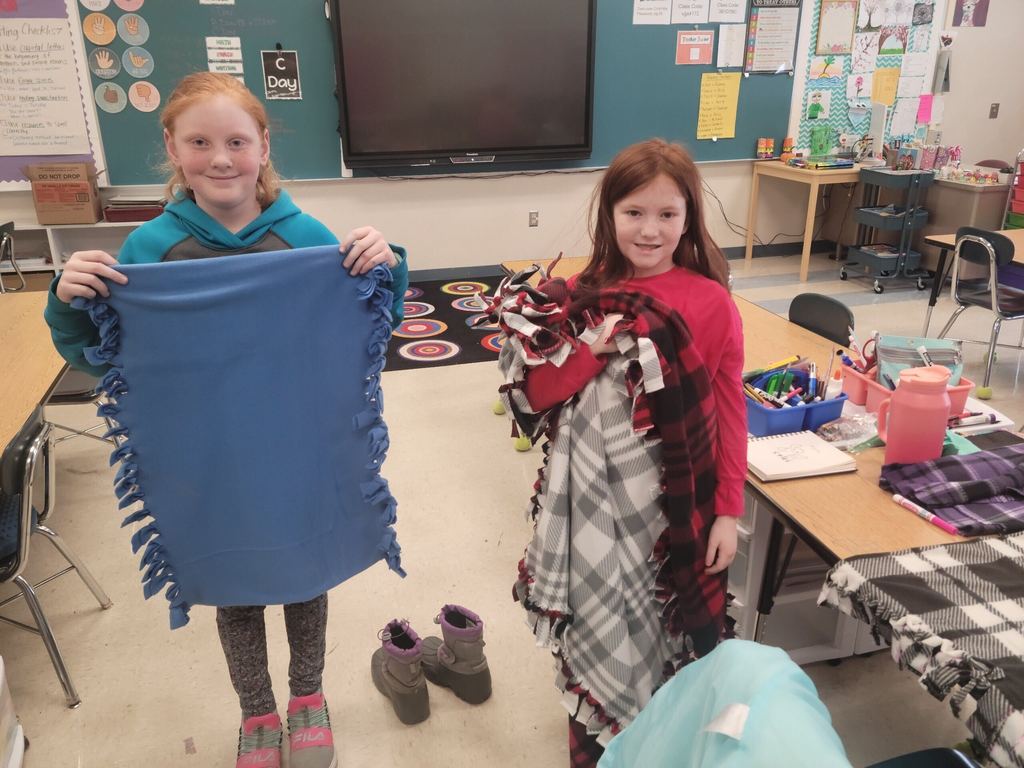 Students showing off blankets they made